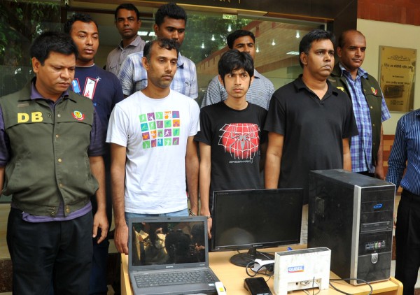 Three arrested bloggers stand with computers and police in the capital. Image by Rehman Asad. Copyright Demotix (2/4/2013)