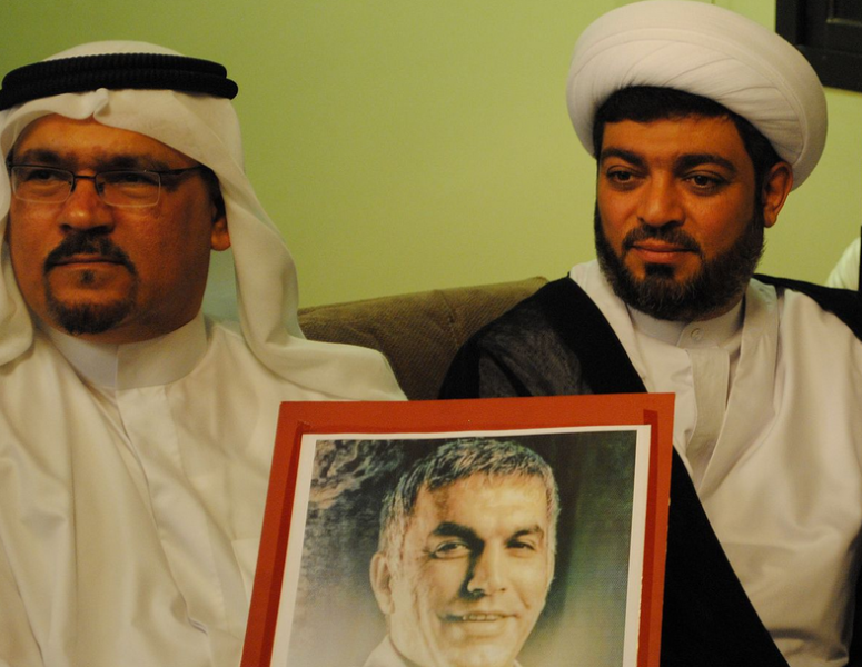 جلال فيروز وحسين الديهي، من أعضاء جمعية الوفاق، رافعين صورة نبيل رجب متضامنين معه.